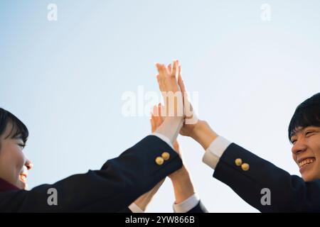 Männliche und weibliche Highschool-Schüler sind High-Fiving Stockfoto