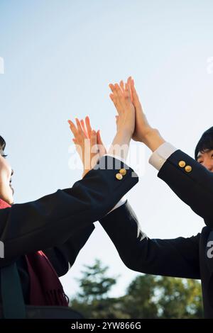 Männliche und weibliche Highschool-Schüler sind High-Fiving Stockfoto