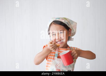 Mädchen trinkt Suppe mit rotem Becher Stockfoto