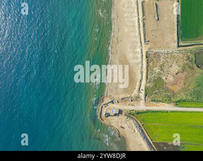 Blick aus der Vogelperspektive auf den Strand von Marquesa und das Restaurant Vascos, wo man den Rückzugsort der Küste des Ebro-Deltas an einem Sommermorgen sehen kann (Katalonien, Spanien) Stockfoto