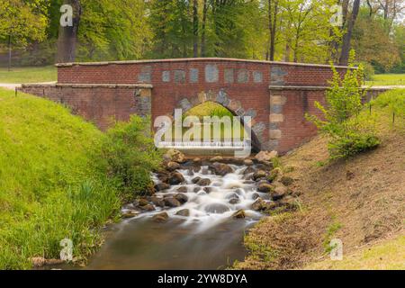 Ruhiger Cascading Stream, Der Durch Die Malerische Stone Arch Bridge Fließt Stockfoto