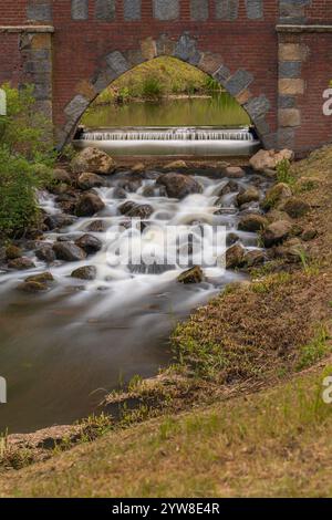 Ruhiger Cascading Stream, Der Durch Die Malerische Stone Arch Bridge Fließt Stockfoto