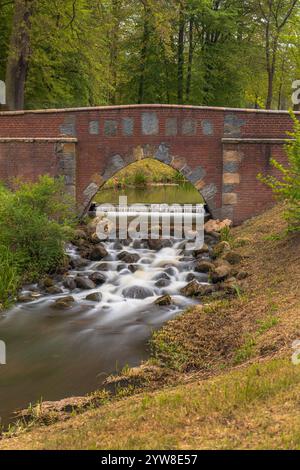 Ruhiger Cascading Stream, Der Durch Die Malerische Stone Arch Bridge Fließt Stockfoto