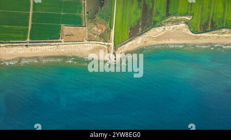 Blick aus der Vogelperspektive auf den Strand von Marquesa und das Restaurant Vascos, wo man den Rückzugsort der Küste des Ebro-Deltas an einem Sommermorgen sehen kann (Katalonien, Spanien) Stockfoto