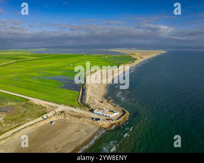 Blick aus der Vogelperspektive auf den Strand von Marquesa und das Restaurant Vascos, wo man den Rückzugsort der Küste des Ebro-Deltas an einem Sommermorgen sehen kann (Katalonien, Spanien) Stockfoto