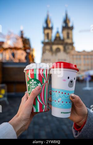 Prag, Tschechische republik - 4. Dezember 2024: Nahaufnahme von zwei jungen Frauen, die auf der Straße von Prag im großen Starbucks-Weihnachtskaffee halten Stockfoto