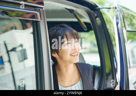 Büroangestellte in ihren 30ern, die aus dem Taxi steigen Stockfoto