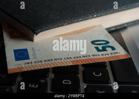 Nahaufnahme einer 50-Euro-Banknote auf einer Tastatur, die Finanztechnologie und Finanztransaktionen darstellt. Stockfoto