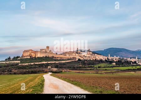 Skyline der Stadt Assisi, Italien mit der Basilika des Heiligen Franz von Assisi in der Abenddämmerung. Stockfoto