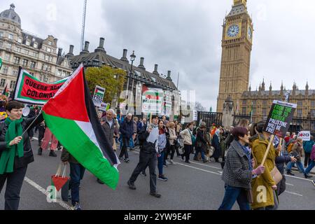 Pro-palästinensische Demonstranten versammeln sich, inszenieren Sterbefälle und marschieren von Whitehall in Solidarität mit Palästina in Zentral-London zur US-Botschaft. Stockfoto