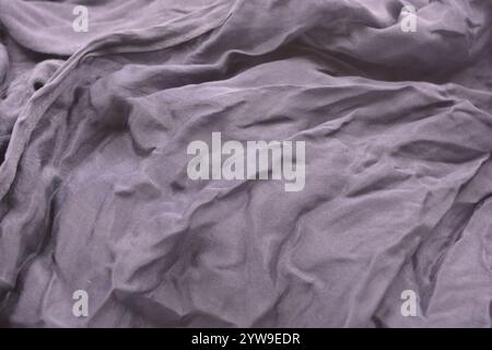 Ungewöhnliche Stoffe, sehr zerknittert, seidendünn, dunkelblaue Baumwolle, Viskose befindet sich auf weißem Kunststoffhintergrund. Stockfoto