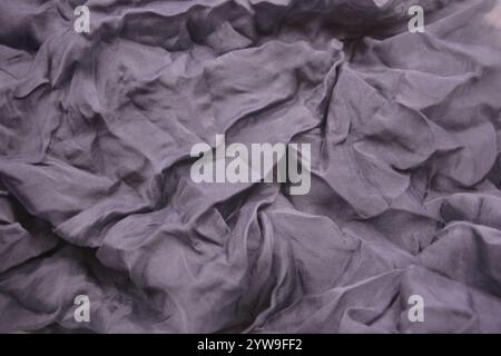 Ungewöhnliche Stoffe, sehr zerknittert, seidendünn, dunkelblaue Baumwolle, Viskose befindet sich auf weißem Kunststoffhintergrund. Stockfoto