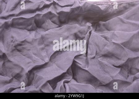 Ungewöhnliche Stoffe, sehr zerknittert, seidendünn, dunkelblaue Baumwolle, Viskose befindet sich auf weißem Kunststoffhintergrund. Stockfoto