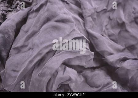 Ungewöhnliche Stoffe, sehr zerknittert, seidendünn, dunkelblaue Baumwolle, Viskose befindet sich auf weißem Kunststoffhintergrund. Stockfoto