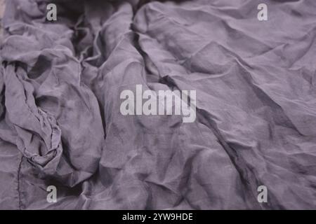 Ungewöhnliche Stoffe, sehr zerknittert, seidendünn, dunkelblaue Baumwolle, Viskose befindet sich auf weißem Kunststoffhintergrund. Stockfoto