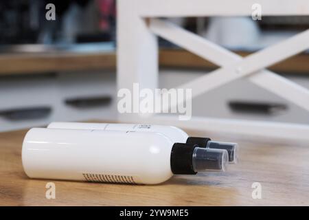 Weiße Flaschen mit schwarzem Spender. Sie liegen nebeneinander auf dem Tisch. Stockfoto