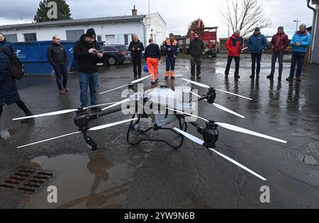 Litovel, Tschechische Republik. Dezember 2024. Feierliche Übergabe der DJI Agras T50 Drohne, die für die effektive Anwendung von Mückensprays in Dörfern in der Nähe des Naturschutzgebiets Litovelske Pomoravi, Litovel, Region Olomouc, verwendet wird, 10. Dezember 2024. Die Drohne ist mit modernster Technologie ausgestattet und ermöglicht den Einsatz von flüssigen oder streuenden Mitteln in der Landwirtschaft. Auf dem Foto links steht der Drohnentechniker der Zulieferfirma Tomas Mrva. Quelle: Ludek Perina/CTK Photo/Alamy Live News Stockfoto