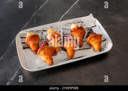 Rechteckiges Tablett aus weißem Porzellan mit Mini-Croissants gefüllt mit Schokolade in verschiedenen Geschmacksrichtungen Stockfoto