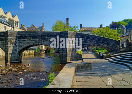 Großbritannien, West Yorkshire, Hebden Bridge, Hebden Old Bridge über Hebden Water im Stadtzentrum. Stockfoto