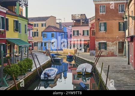 Farbenfrohe Häuser am Wasserweg zwischen „Fondamenta San Mauro“ und „Fondamenta degli Assassini“ mit Booten, die im Wasser auf der Insel liegen Stockfoto