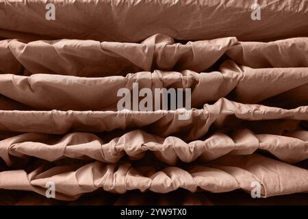 Abstrakte braune Stoffstruktur mit gewellten Lagen und Falten für symmetrische Muster. Stockfoto