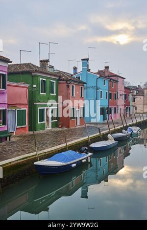 Farbenfrohe Häuser neben dem Wasserweg zwischen 'Riva dei Santi' und 'Fondamenta di Terranova' mit Booten, die im Wasser auf der Insel Burano liegen Stockfoto