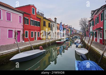 Farbenfrohe Häuser neben dem Wasserweg zwischen 'Riva dei Santi' und 'Fondamenta di Terranova' mit Booten, die im Wasser auf der Insel Burano liegen Stockfoto