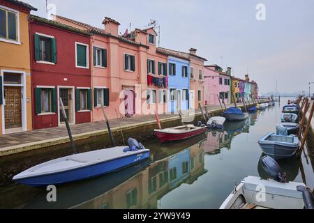 Farbenfrohe Häuser neben dem Wasserweg bei „Fondamenta Cao di Rio a Sinistra“ mit Booten, die im Wasser auf der Insel Burano, Italien, Europa liegen Stockfoto