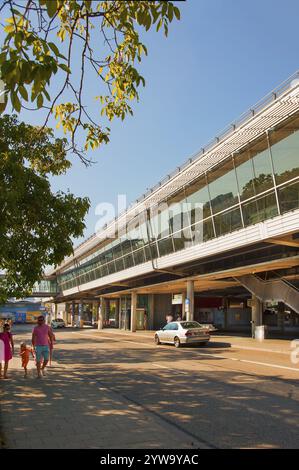 Moderner Bahnhof mit Glasfassade, umgeben von Bäumen, an einem sonnigen Tag, Froettmaning Parkhaus von außen, Busbahnhof, München, B Stockfoto