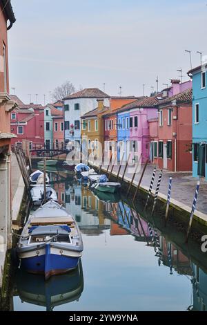 Farbenfrohe Häuser neben dem Wasserweg zwischen 'Riva dei Santi' und 'Fondamenta di Terranova' mit Booten, die im Wasser auf der Insel Burano liegen Stockfoto