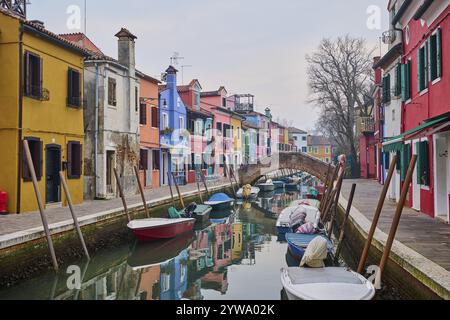 Farbenfrohe Häuser neben dem Wasserweg zwischen 'Riva dei Santi' und 'Fondamenta di Terranova' mit Booten, die im Wasser auf der Insel Burano liegen Stockfoto