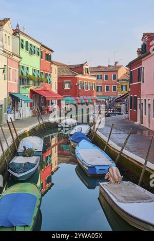 Farbenfrohe Häuser am Wasserweg zwischen „Fondamenta San Mauro“ und „Fondamenta degli Assassini“ mit Booten, die im Wasser auf der Insel liegen Stockfoto