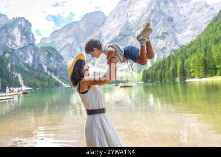 Glückliche Mutter hebt ihren Sohn auf und genießt Sommerurlaub am Pragser wildsee in den dolomiten, Südtirol, alpen, italien Stockfoto