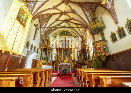 Mit einem reich verzierten Altar, lebhaften Fresken und einer traditionellen Holzkanzel, das Innere der St. Die Kirche Magdalena besticht im val di funes Stockfoto
