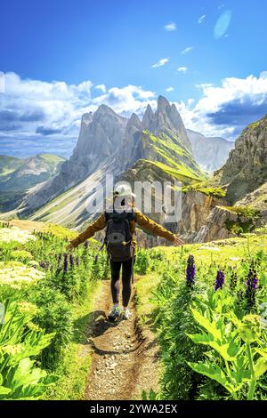 Weibliche Wanderer, die auf einem Pfad spazieren und die wunderschöne Berglandschaft während der Sommerwanderung in seceda, dolomiten, italien genießen Stockfoto