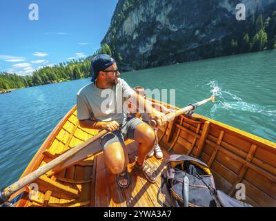 Touristen genießen einen sonnigen Rudertag auf dem berühmten pragser See, umgeben von der atemberaubenden Landschaft der dolomiten Stockfoto