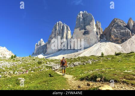 Touristen genießen eine Sommerwanderung auf einem malerischen Pfad, der zu den majestätischen Gipfeln der Tre cime di lavaredo in den dolomiten führt Stockfoto