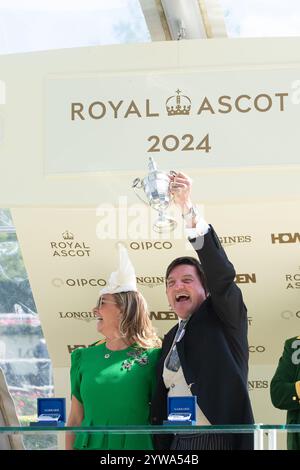 Ascot, Berkshire, Großbritannien. Juni 2024. Besitzer David Howden hält mit seiner Frau den Siegerpokal, nachdem er am zweiten Tag von Royal Ascot 2024 den von Jockey Oisin Murphy geritten LÖWEN auf der Ascot Racecourse in Berkshire gewonnen hatte. Besitzer David Howden, Trainer John & Thady Gosden. Kredit: Maureen McLean/Alamy Stockfoto