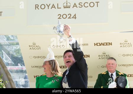 Ascot, Berkshire, Großbritannien. Juni 2024. Besitzer David Howden hält mit seiner Frau den Siegerpokal, nachdem er am zweiten Tag von Royal Ascot 2024 den von Jockey Oisin Murphy geritten LÖWEN auf der Ascot Racecourse in Berkshire gewonnen hatte. Besitzer David Howden, Trainer John & Thady Gosden. Kredit: Maureen McLean/Alamy Stockfoto