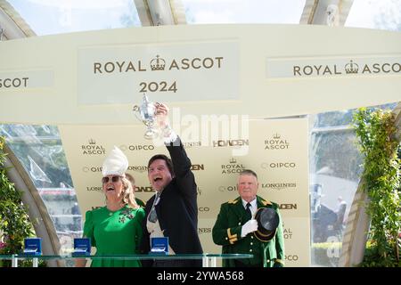 Ascot, Berkshire, Großbritannien. Juni 2024. Besitzer David Howden hält mit seiner Frau den Siegerpokal, nachdem er am zweiten Tag von Royal Ascot 2024 den von Jockey Oisin Murphy geritten LÖWEN auf der Ascot Racecourse in Berkshire gewonnen hatte. Besitzer David Howden, Trainer John & Thady Gosden. Kredit: Maureen McLean/Alamy Stockfoto