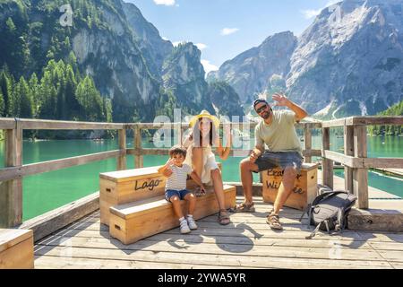 Glückliche Familie winkt am pragser wildsee, auch bekannt als Pragser wildsee, und genießt Sommerurlaub inmitten der atemberaubenden Landschaft der dolomiten in italien Stockfoto