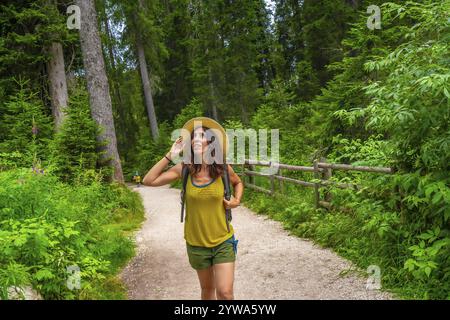 Weibliche Touristen, die im Sommer einen Spaziergang entlang eines Waldweges in der Nähe des karersee in den italienischen dolomiten genießen Stockfoto