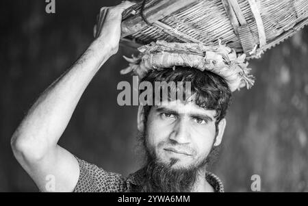 Porträt eines Mannes mit einem Korb auf dem Kopf, monochrom, Dhaka, Bangladesch, Asien Stockfoto