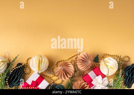 Weihnachtlicher flacher Hintergrund im gemütlichen nordischen Hygge-Stil, Komposition mit traditionellen skandinavischen Papier-Wabenornamenten, Geschenkboxen, goldener Granat Stockfoto