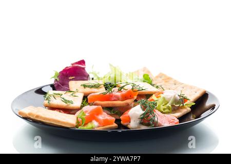Kleine Snack Canapes mit Crackern und leicht gesalzenem rotem Fisch Lachs, isoliert auf weißem Hintergrund. Stockfoto