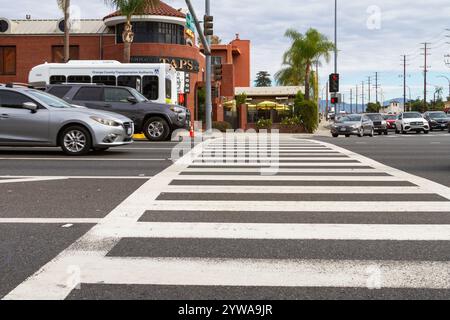 Brea, KALIFORNIEN, USA - 25. November 2024: Zebra-Crosswalk mit Autos an einer Kreuzung in Brea, Kalifornien. Stockfoto