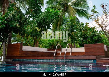 Erleben Sie einen luxuriösen Rückzugsort am Pool in einem tropischen Paradies für ultimative Entspannung Stockfoto