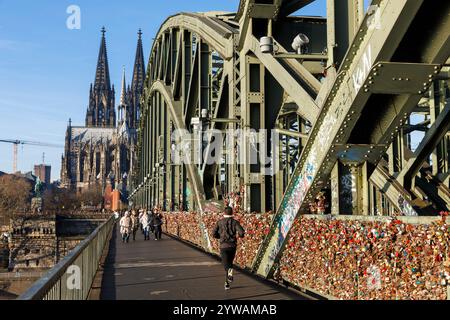 Vorhängeschlösser am Fußwegszaun der Hohenzollerner Eisenbahnbrücke, dem Dom, Köln, Deutschland. Vorhaengeschloesser als Liebesschloesser am Zaun en Stockfoto