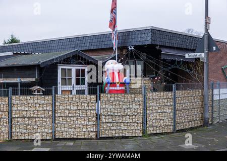 Aufblasbarer Weihnachtsmann in einem umzäunten Wohnhaus im Stadtteil Bocklemuend, Maschendrahtzaun, Köln, Deutschland. Aufblasbarer Weihnachtsmann an e Stockfoto