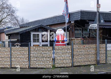 Aufblasbarer Weihnachtsmann in einem umzäunten Wohnhaus im Stadtteil Bocklemuend, Maschendrahtzaun, Köln, Deutschland. Aufblasbarer Weihnachtsmann an e Stockfoto